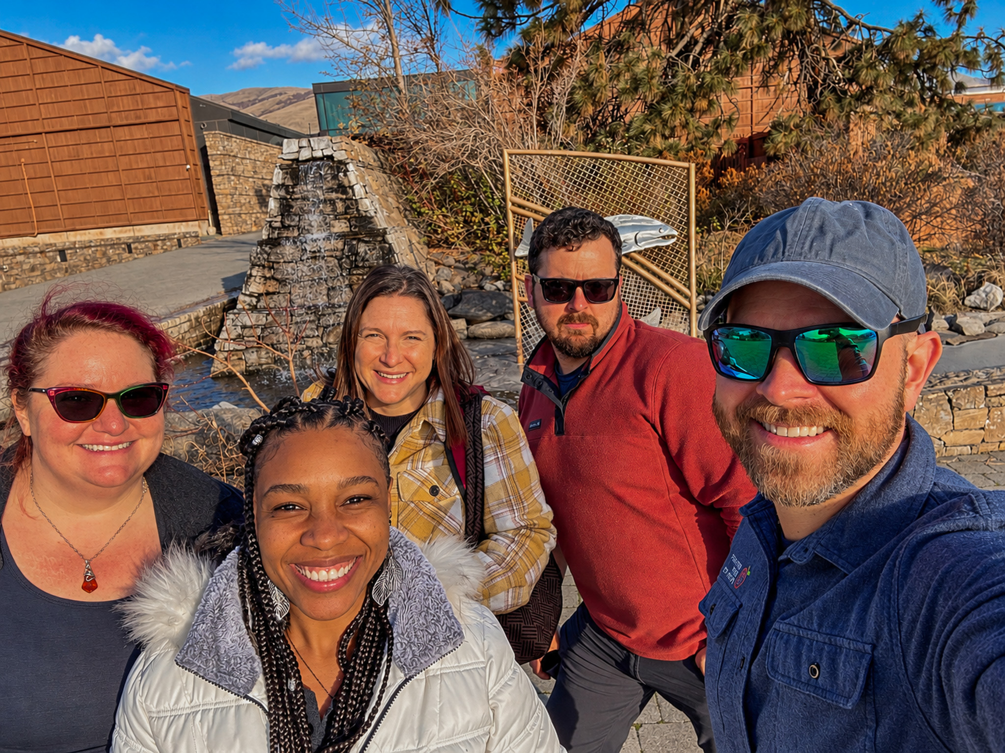Five people posing together outdoors